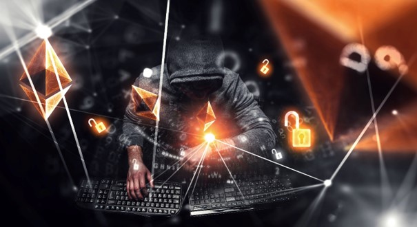 Hacker sitzt vor zwei Laptops