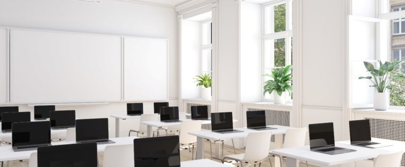 Digitalisierter Klassenraum mit Laptops auf den einzelnen Plätzen