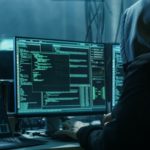 Verdeckter Hacker in einem Versteck mit dunkler Atmosphäre und mehreren Displays