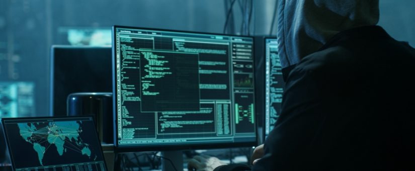 Verdeckter Hacker in einem Versteck mit dunkler Atmosphäre und mehreren Displays