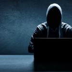 Hacker maskiert vor einem Laptop