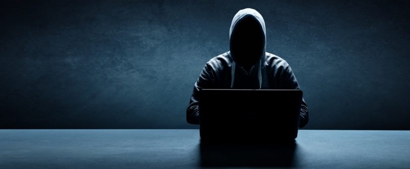 Hacker maskiert vor einem Laptop
